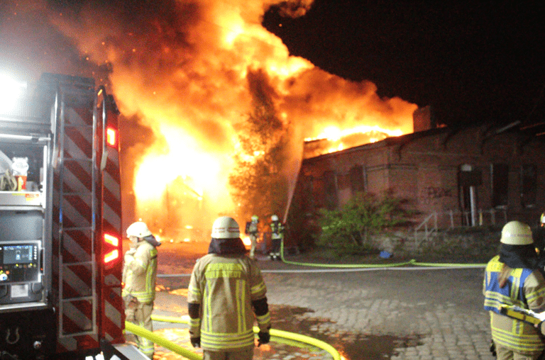 Feuerwehrleute betrachten den Brand und wägen die Lage ab