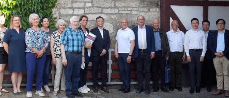 Die Gastgeber und die chinesischen Gäste posieren für ein Gruppenfoto