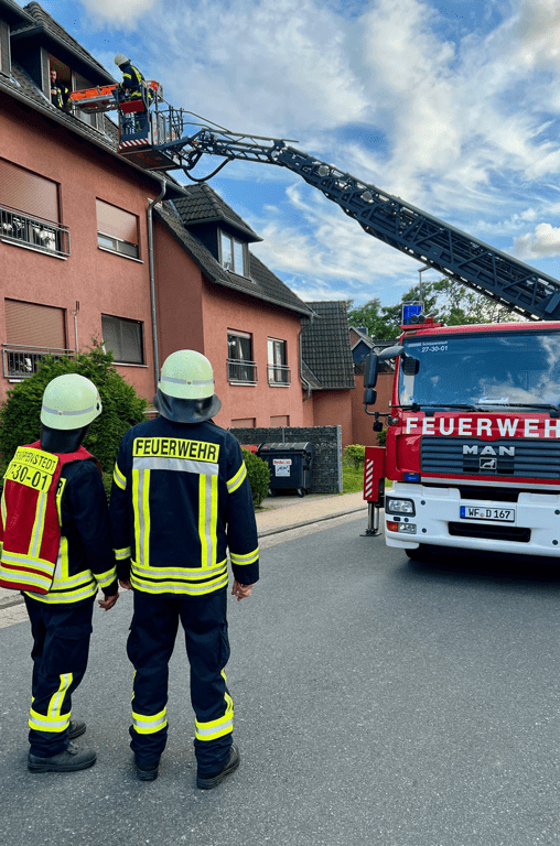 Die Feuerwehrleute begutachten die Übung an der Fenstergaube von unten