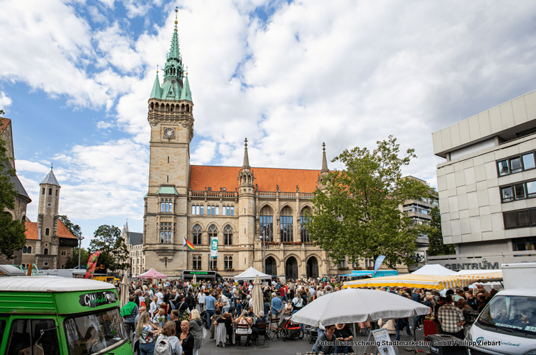 Marktbeschicker und Besucher auf dem Baunschweiger Abendmarkt mit Rathaus im Hintergrund